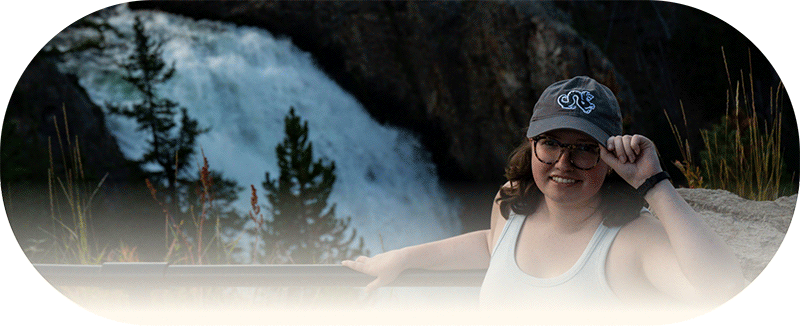 Olivia in a Drexel hat in front of a waterfall