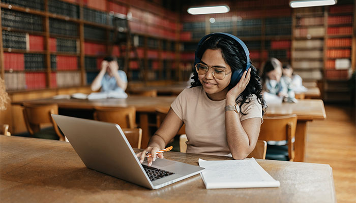 Student working at laptop in university library